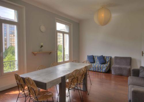 un salon avec une grande table et des chaises dans l'établissement Appartement de caractère avenue du Prado 4 chambres, à Marseille