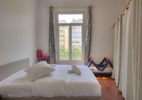 une chambre avec un lit et une grande fenêtre dans l'établissement Appartement de caractère avenue du Prado 4 chambres, à Marseille