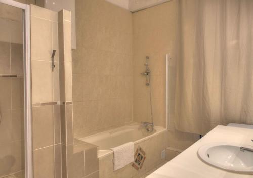 une salle de bain avec une baignoire, un lavabo et une douche dans l'établissement Appartement de caractère avenue du Prado 4 chambres, à Marseille