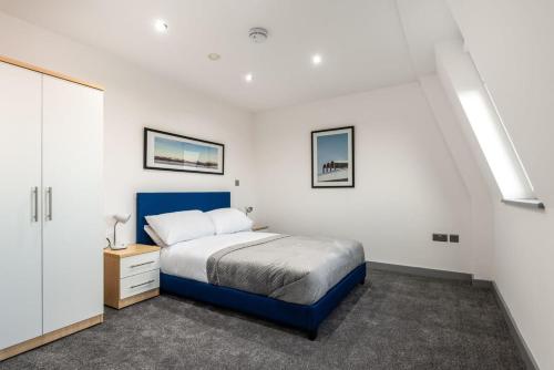 a bedroom with a blue bed and white walls at Modern 1 Bedroom Apartment in Central Hull in Hull