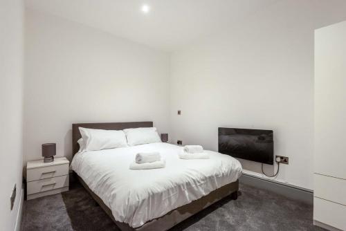 Contemporary 1 Bed Budget Apartment in Darlington في دارلينغتون: غرفة نوم بسرير ابيض وتلفزيون