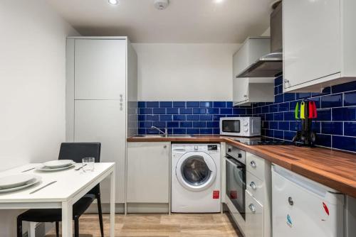 a kitchen with a washing machine and a white table at Cosy 1 Bed Budget Flat in Central Darlington in Darlington