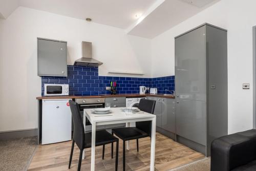 a small kitchen with a white table and chairs at Lovely 1 Bed Budget Apartment in Central Darlington in Darlington