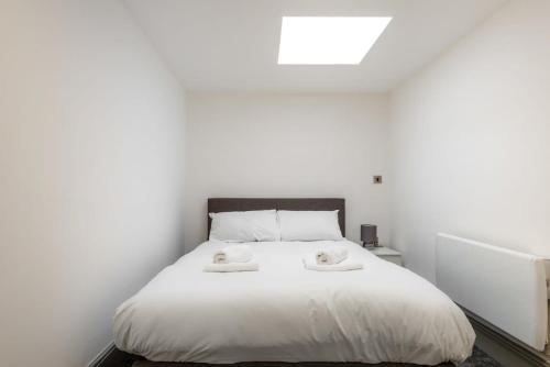 ein Schlafzimmer mit einem weißen Bett mit zwei Handtüchern darauf in der Unterkunft Centrally Located Budget 1 Bed Flat in Darlington in Darlington