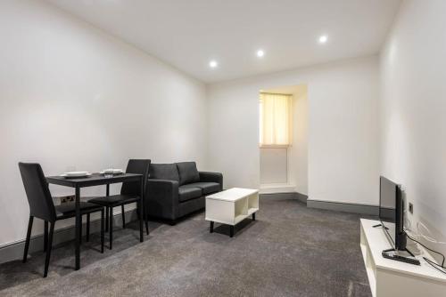 a living room with a table and a couch and a television at Smart 1 Bed Budget Apartment in Darlington in Darlington