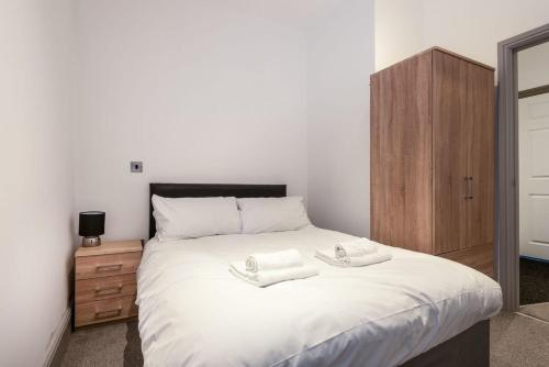 a bedroom with a large white bed with two towels on it at Modern 1 Bed Budget Apartment in Darlington in Darlington