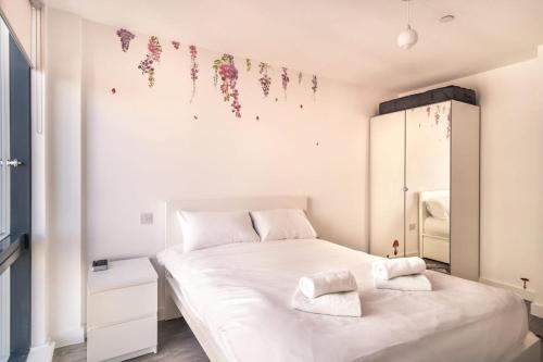 ein Schlafzimmer mit einem großen weißen Bett mit Handtüchern darauf in der Unterkunft Spacious & Modern 1 Bed Apartment Manchester in Manchester