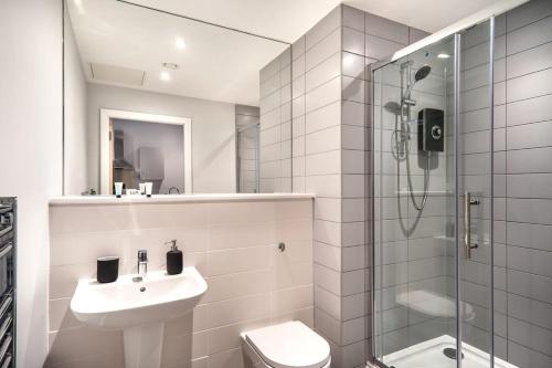 y baño con aseo, lavabo y ducha. en Modern & Spacious 2 Bed Apartment in Waterloo Liverpool en Waterloo