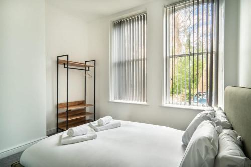 Cama blanca en habitación con ventana en Modern 2 Bed Apartment in Waterloo Liverpool en Liverpool