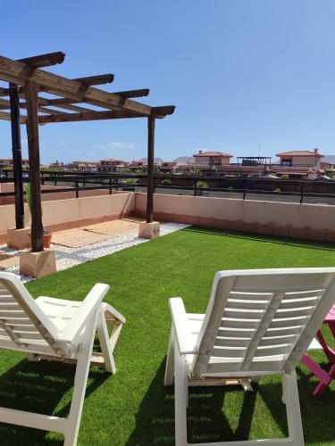 two white lawn chairs sitting on a roof at Villa Punta Calma in Majanicho