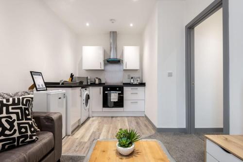a kitchen and living room with a couch and a table at 1 Bedroom Budget Apartment in Central Doncaster in Doncaster