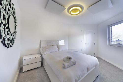 a white bedroom with a large white bed with a yellow ceiling at Stylish and Bright 2 Bed Apartment in Ashford in Ashford