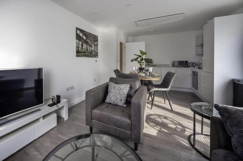 a living room with a couch and a tv and a table at Stylish and Bright 2 Bed Apartment in Ashford in Ashford