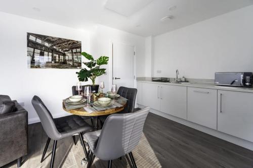Una cocina y un comedor con mesa y sillas. en Stylish and Bright 2 Bed Apartment in Ashford, en Ashford