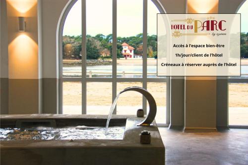 a sink in a room with a sign in front of a window at Hôtel du Parc & Spa in Hossegor
