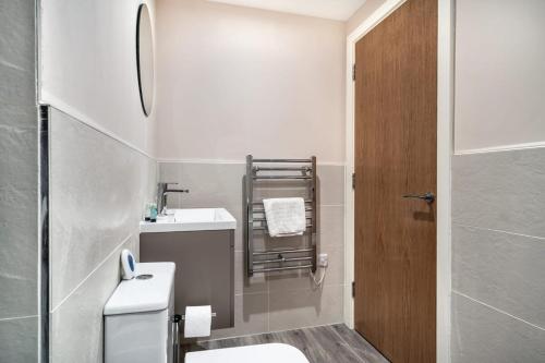 La salle de bains est pourvue de toilettes, d'un lavabo et d'une douche. dans l'établissement Bright & Modern 2 Bed Apartment in Manchester, à Manchester