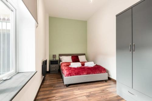 a bedroom with a bed with a red blanket at Characterful 2 Bed Apartment with Parking in Central Hull in Hull