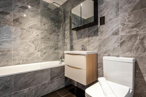 a bathroom with a toilet and a sink and a tub at Characterful 2 Bed Apartment with Parking in Central Hull in Hull