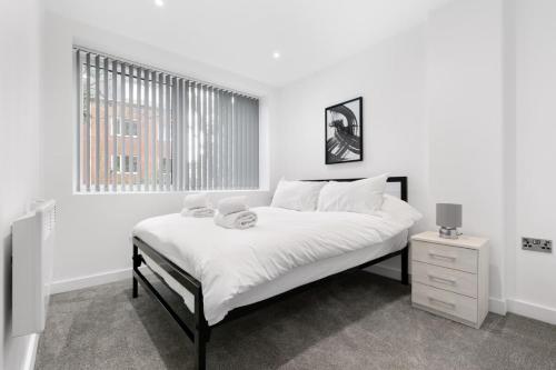 een witte slaapkamer met een bed en een raam bij Modern 2 Bedroom Apartment in Central Newbury in Newbury
