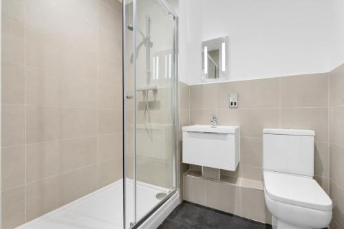 uma casa de banho com um WC e uma cabina de duche em vidro. em Modern 2 Bedroom Apartment in Central Newbury em Newbury