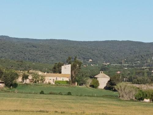 a small village with a field and mountains in the background at Mas Fina in Palafrugell