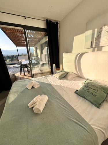 une chambre avec un lit avec deux serviettes dessus dans l'établissement Villa Porra avec piscine 8 pers vue montagne, à Porto-Vecchio