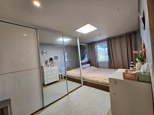 Schlafzimmer mit einem Bett und einem Spiegel in der Unterkunft 2022 New Entire house for family in Boseong
