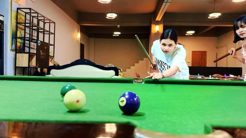 two women playing a game of snooker on a pool table at 怡程酒店ECHENG HOTEL in Sihanoukville