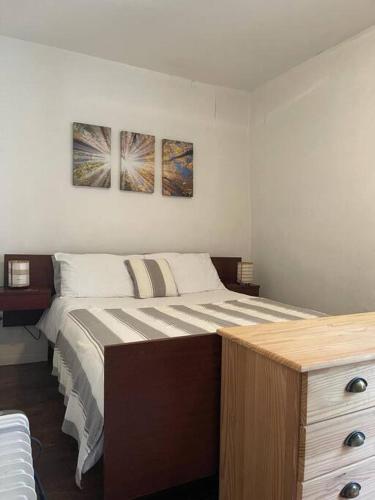 une chambre avec un lit et deux tableaux au mur dans l'établissement La Petite Maison Rustique, à Eyzerac