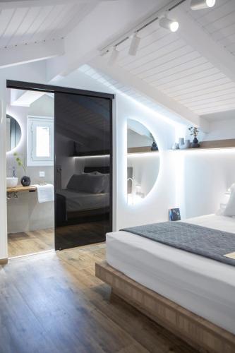 a white bedroom with a large bed and a bathroom at Skyview Suites in Lefkada Town