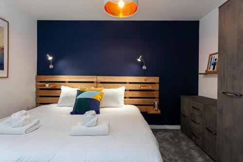 - une chambre avec un grand lit et un mur bleu dans l'établissement Stunning 2 Bed Flat 5min to Old Trafford Stadium, à Manchester