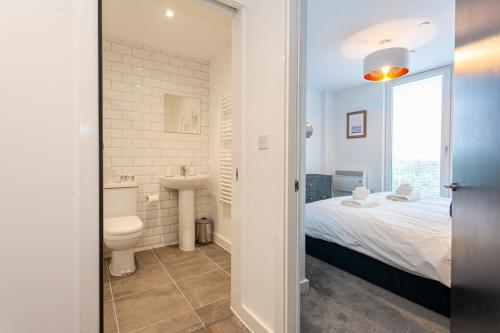 y baño con cama, aseo y lavamanos. en Amazing 2 Bed Apartment 5min To Old Trafford, en Mánchester