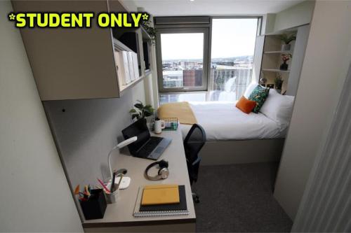 um pequeno quarto com uma cama e uma secretária com um computador em Student Only Zeni Ensuite Rooms Belfast em Belfast