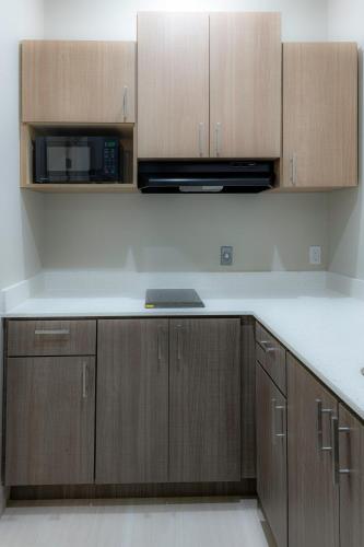 a kitchen with wooden cabinets and a white counter top at Azul Inn in Houston