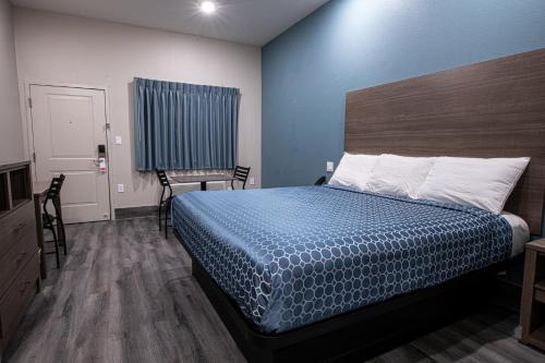 a bedroom with a bed and a table and a chair at Azul Inn in Houston