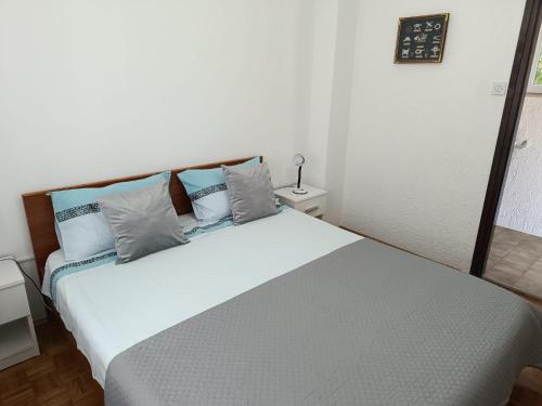 um quarto com uma grande cama branca com almofadas azuis em Apartman Ena em Senj