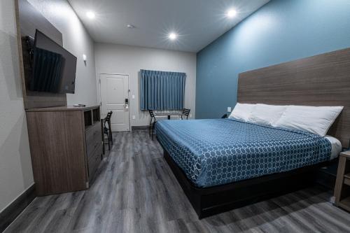 a bedroom with a bed and a television in it at Azul Inn in Houston