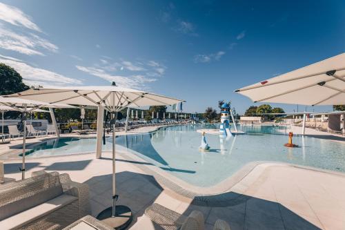 a large swimming pool with umbrellas and people in it at Maistra Camping Veštar Pitches in Rovinj