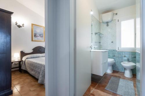 ein Bad mit einem Bett, einem WC und einem Waschbecken in der Unterkunft Casa Mariano in Costa Rei