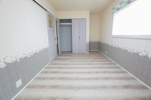 an empty hallway with a door and a window at 忍野八海まで車で４分！ワンランク上のアウトドアライフ堪能できる【LongevityVillage】A in Minamitsuru