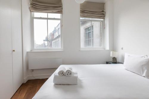 a bedroom with a white bed with two rolled up towels at Stunning 1 Bedroom Apartment in Holborn London in London