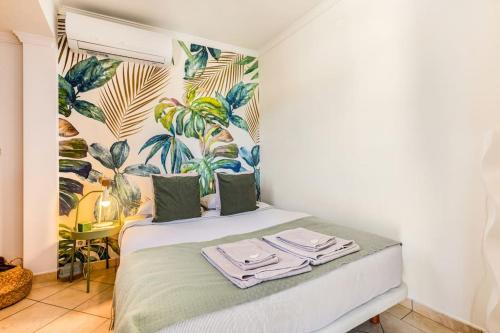 a bedroom with a bed with a tropical wallpaper at Casinha da Jade in Albufeira