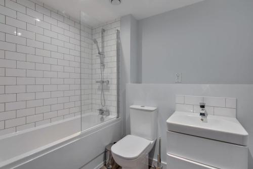 Baño blanco con aseo y lavamanos en Bright 1 Bedroom Apartment, Central Birmingham, en Birmingham
