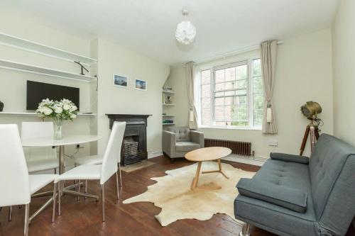 uma sala de estar com um sofá azul e uma mesa em Lovely 2 Bedroom Apartment in Waterloo em Londres