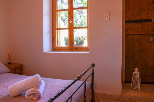 a bedroom with a bed and a window at Coastal Stone Residence with Spectacular Scenery in Kitriaí
