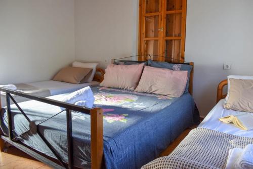 a bedroom with two beds with blue sheets at Coastal Stone Residence with Spectacular Scenery in Kitriaí