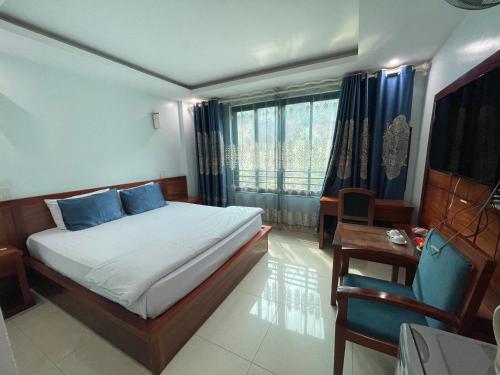 a bedroom with a bed and a desk and a window at Khách sạn Phương Thuý 1 in Yên Bái