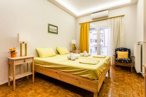 um quarto com uma cama grande com lençóis amarelos em Athens Perfect Spot - Zografou Cozy Home em Atenas