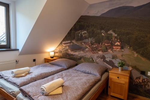 Koliba Pod Horů في Dolní Bečva: سريرين في غرفة مع لوحة على الحائط