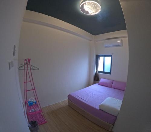 a bedroom with a bed and a ladder in it at sky blue hostel in Lanyu